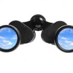 Binoculars with a clear blue sky reflection, symbolizing a positive outlook on pediatric board exam results.