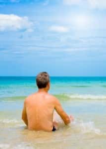 Man relaxing in the ocean, symbolizing the reward and relaxation after passing the pediatric boards.