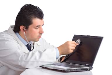 Doctor examining a laptop with a stethoscope representing strategies to skyrocket your score in Pediatric Board Exams