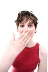 Woman with a surprised expression and hand over mouth, symbolizing a sudden realization or mistake.