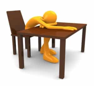 Person resting head on a desk out of exhaustion, representing the struggle of studying for the pediatric boards.