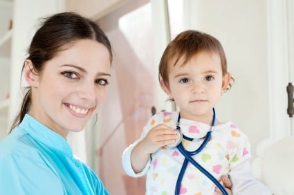 Smiling female pediatrician with child holding a stethoscope representing a recertified pediatrician