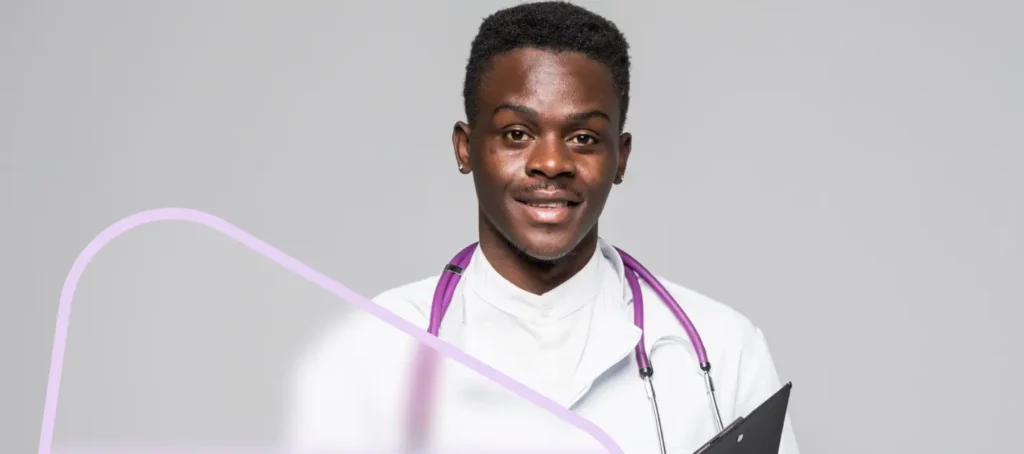 Home Smiling male pediatrician with a stethoscope, representing confidence and success in board exam preparation.