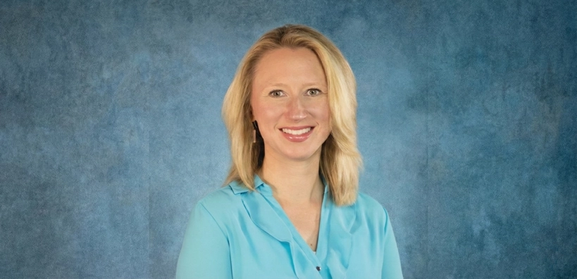 High Risk Female pediatrician, Dr. Kristen Madea smiling in front, because she passed with Pediatrics Board Review (PBR).