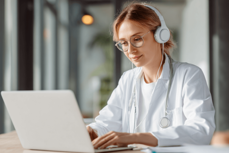 Pediatric resident studying online with headphones and a laptop, reflecting the article’s discussion of balancing digital and hardcopy resources for improving in-training exam performance.