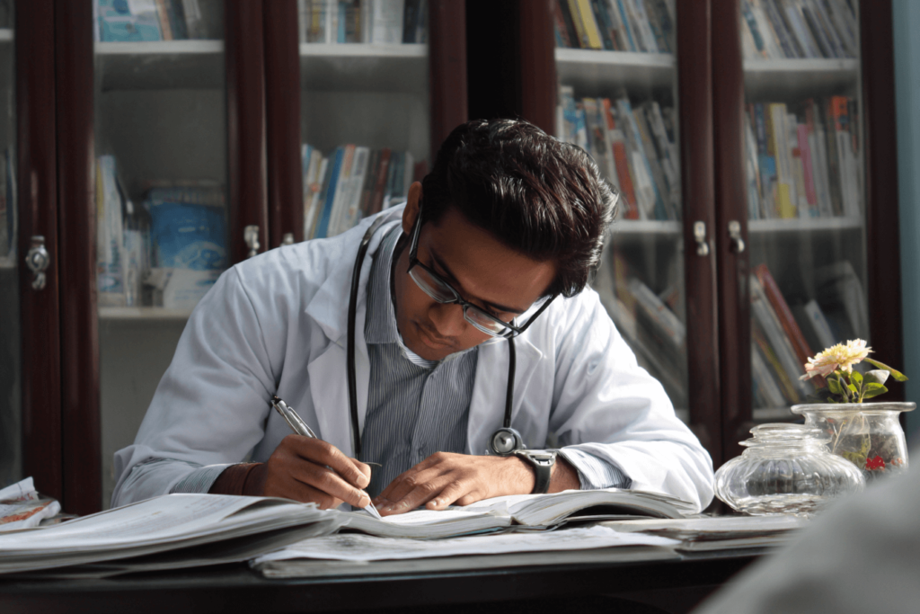 How Many AAP PREP Questions Should I Do? Doctor studying with textbooks to practice and prepare for pediatric board exam questions