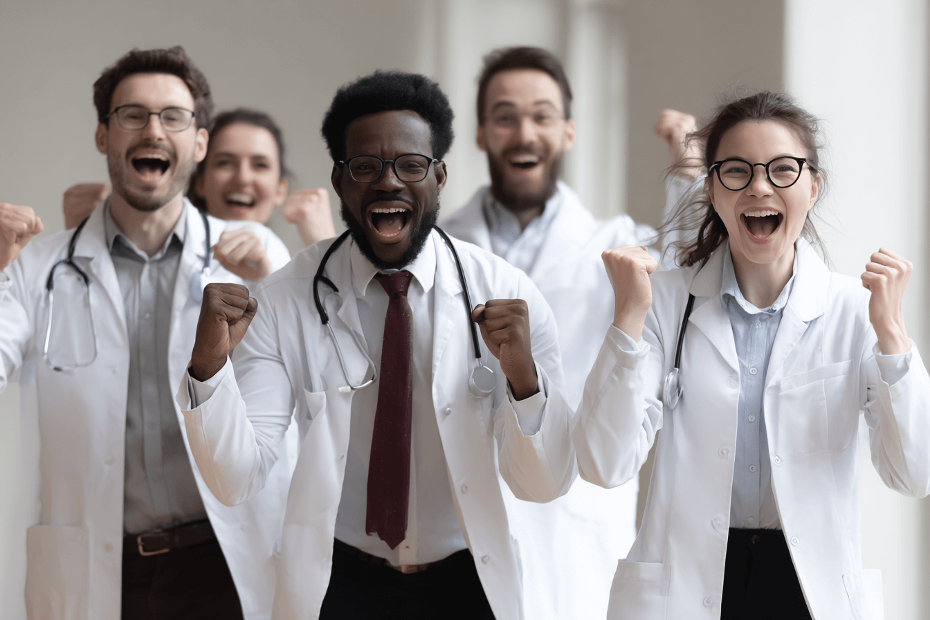 Group of joyful doctors celebrating success after passing the pediatric board exam — symbolizing hope and achievement.